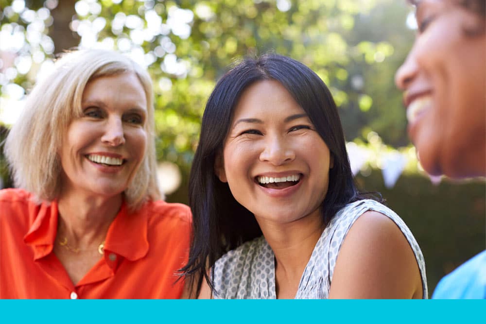 Community_ group of women smiling and talking outdoors