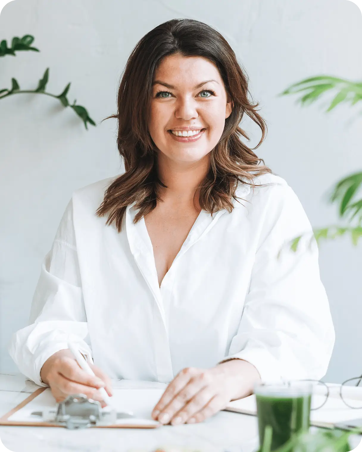 smiling woman in a white shirt sitting at a desk